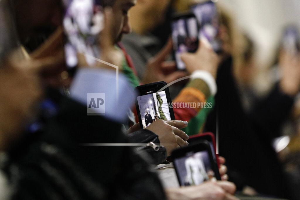 Kamil Zihnioglu FILE - In this Feb. 27, 2019 file photo, guests use with their cell phones to record the Mugler ready to wear Fall-Winter 2019-2020 collection, that was presented in Paris. The coronavirus pandemic has instilled extra unpredictability into the already fickle Paris Fashion Week. After first canceling the July shows for menswear and Haute Couture, the French fashion federation has now organized an unprecedented schedule of digital-only events instead. (AP Photo/Kamil Zihnioglu, File)