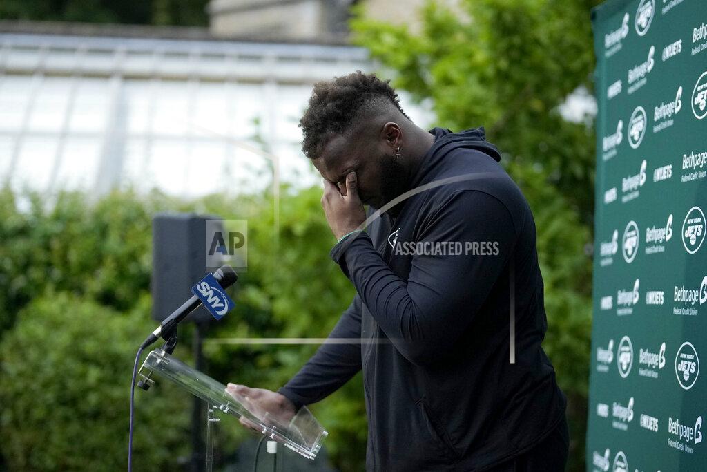New York Jets' defensive lineman John Franklin-Myers is overcome with emotion as he speaks about signing his new contract during a press conference after an NFL practice session at Hanbury Manor Marriott Hotel and Country Club near the town of Ware in south east England, Friday, Oct. 8, 2021. The New York Jets are preparing for an NFL regular season game against the Atlanta Falcons in London on Sunday. (AP Photo/Matt Dunham)