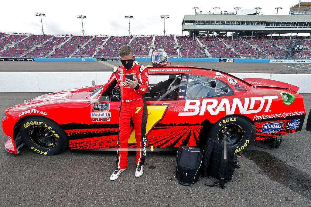Ralph Freso Justin Allgaier looks at his phone as he stands with his race car on pit road prior to the NASCAR Xfinity Series auto race at Phoenix Raceway, Saturday, Nov. 7, 2020, in Avondale, Ariz. (AP Photo/Ralph Freso)