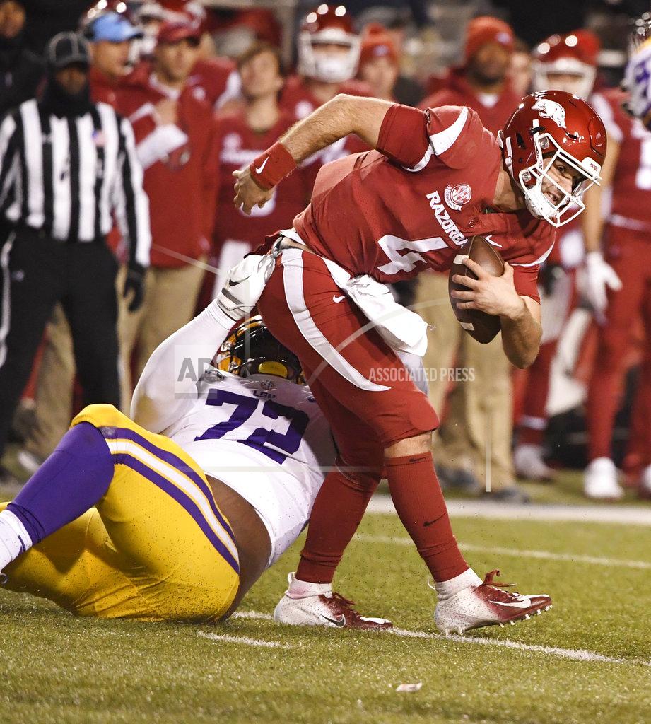 Michael Woods Arkansas quarterback Ty Storey tries to shake LSU defender Tyler Shelvin during the second half of an NCAA college football game, Saturday, Nov. 10, 2018, in Fayetteville, Ark. LSU won, 24-17. (AP Photo/Michael Woods)