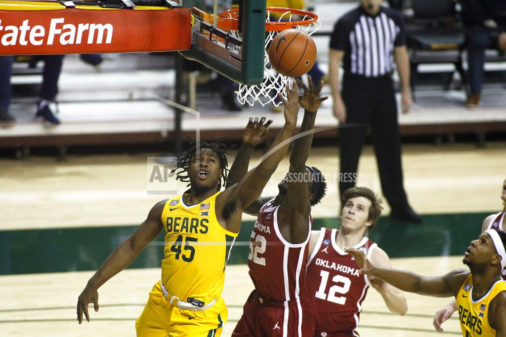 Ray Carlin Baylor guard Davion Mitchell (45) drives to the basket as Oklahoma forward Kur Kuath, center, defends and Oklahoma guard Austin Reaves (12) looks on during the first half of an NCAA college basketball game on Wednesday, Jan. 6, 2021, in Waco, Texas. (AP Photo/Ray Carlin)