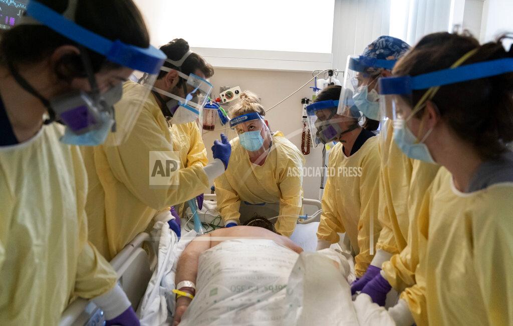 David Goldman A medical team helps turn over a COVID-19 patient on a respirator inside the intensive care unit at Kent Hospital, Monday, Dec. 28, 2020, in Warwick, R.I. Kent hospital opened a field hospital on Nov. 30, just before Rhode Island's infection rate became the highest in the world. Kent Hospital was using all its beds for its sickest COVID-19 patients, and needed somewhere for the overflow. (AP Photo/David Goldman)
