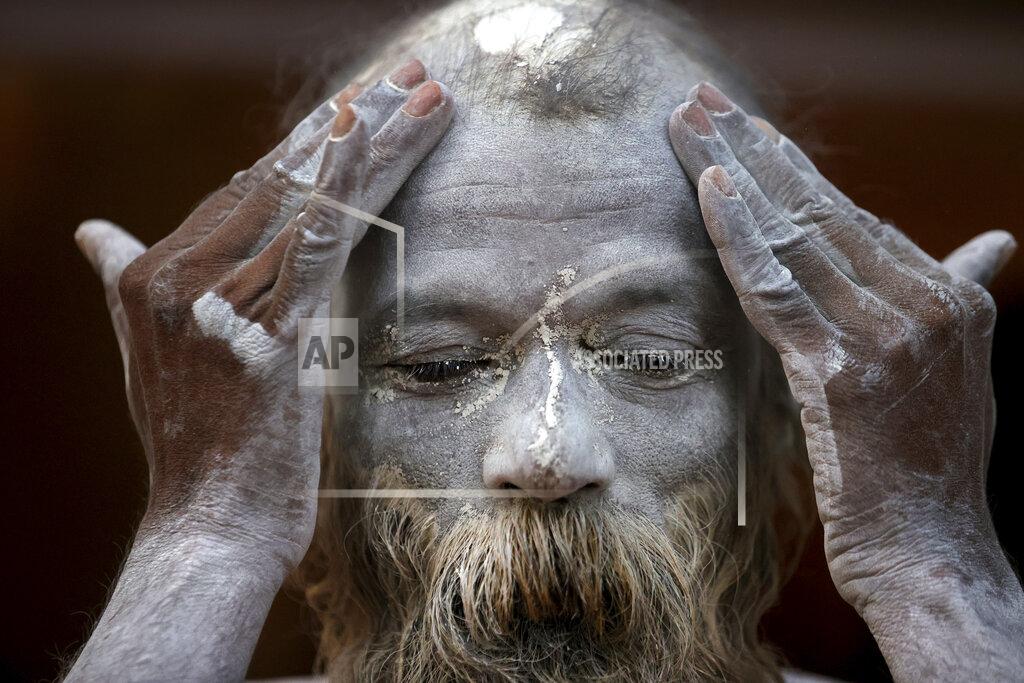 Karma Sonam A Naga Sadhu or Naked Hindu holy man rubes ash as he prepares to take holy dips in the river Ganges during Shahi snan or a Royal bath during Kumbh mela, in Haridwar in the Indian state of Uttarakhand, Monday, April 12, 2021. As states across India are declaring some version of a lockdown to battle rising Covid cases as part of a nationwide second-wave, thousands of pilgrims are gathering on the banks of the river Ganga for the Hindu festival Kumbh Mela. The faithful believe that a dip in the waters of the Ganga will absolve them of their sins and deliver them from the cycle of birth and death. (AP Photo/Karma Sonam)