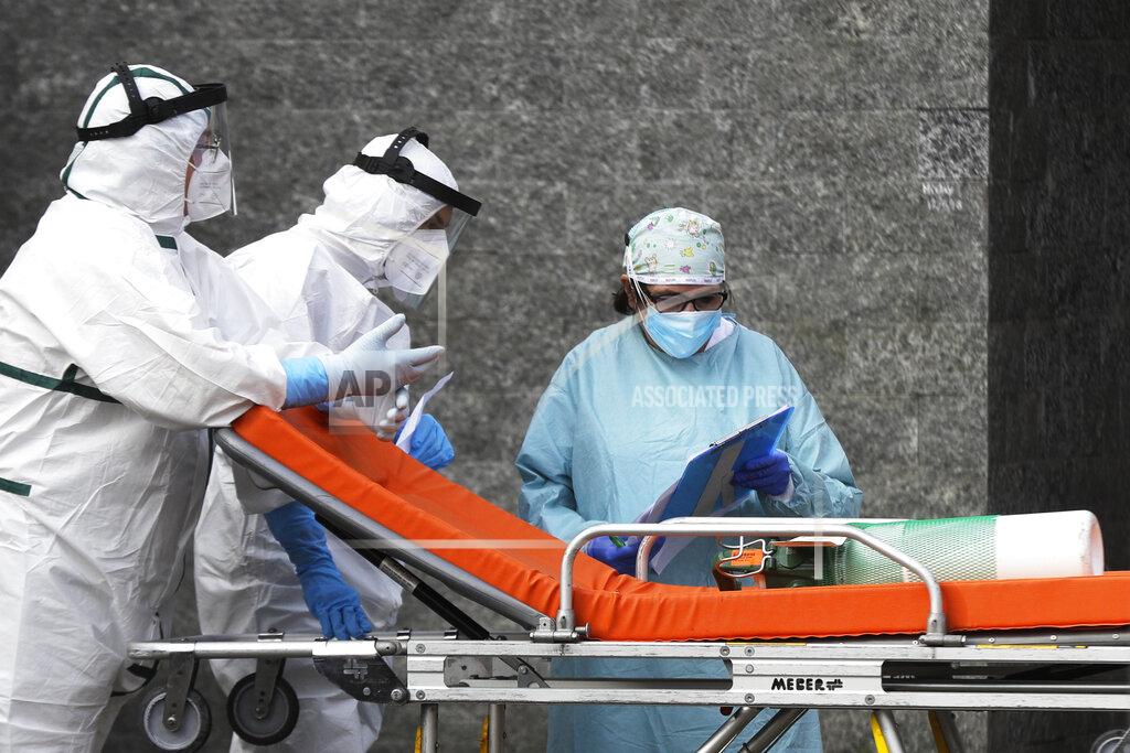 Gregorio Borgia An oxygen canister is carried on a stretcher outside the first aid department of the Cardarelli hospital in Naples, Italy, Friday, Nov. 13, 2020. Outside the ER entrance of Cardarelli, the main health care facility for densely populated Naples, those desperate for oxygen for loved ones lined up in their cars, waiting for nurses to bring tanks of the life-saving element. (AP Photo/Gregorio Borgia)