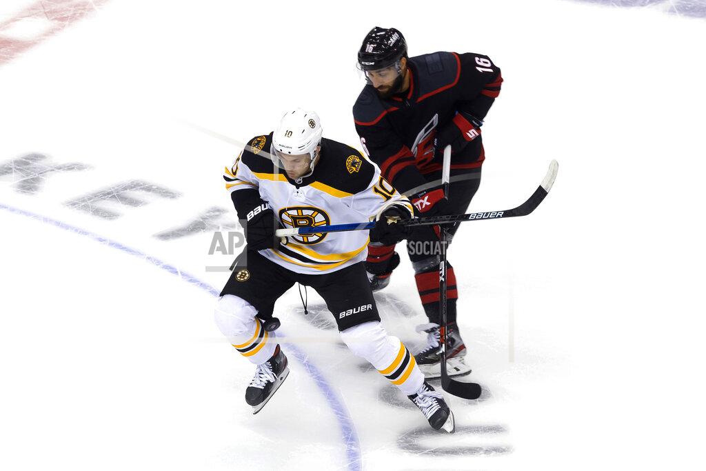 Chris Young Boston Bruins' Anders Bjork (10) and Carolina Hurricanes Vincent Trocheck (16) battle for the puck during first period NHL Eastern Conference Stanley Cup playoff game in Toronto on Saturday, Aug. 15, 2020. (Chris Young/The Canadian Press via AP)