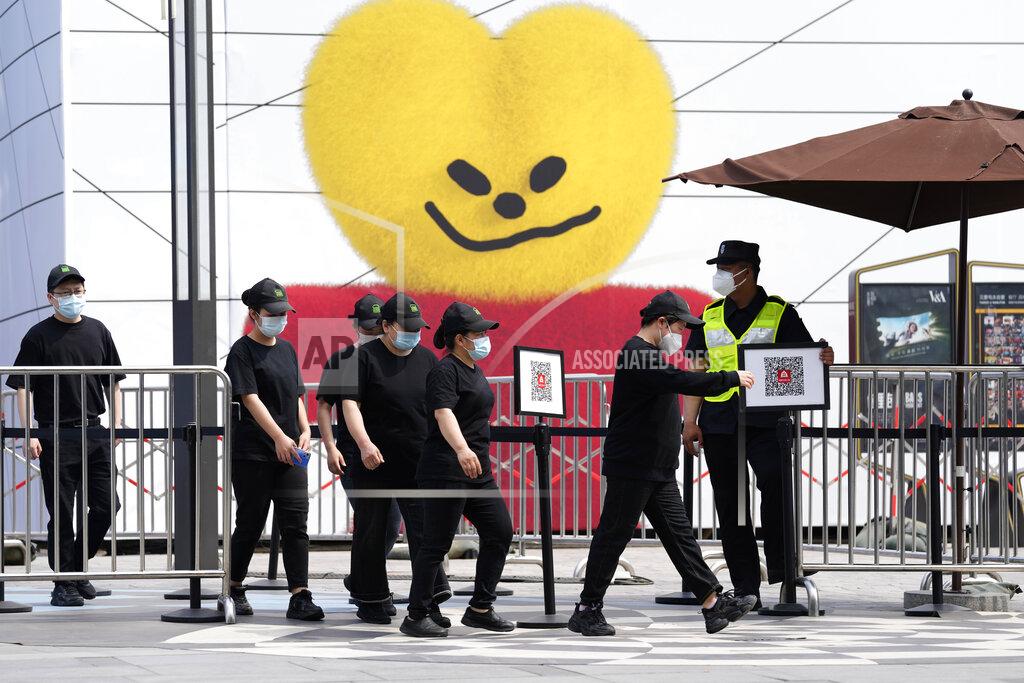Ng Han Guan Workers walk out from a partial closed mall area on Monday, May 23, 2022, in Beijing. (AP Photo/Ng Han Guan)