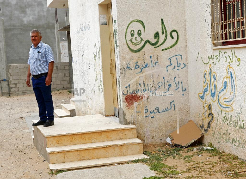 Adel Hana Abdelwahab Elbasyouni, an uncle of Loay Elbasyouni, a space engineer who was part of the NASA team that made history this month by launching an experimental helicopter from the surface of Mars, stands on the porch of the house decorated in accolades to him, where Loay's family used to live, in Beit Hanoun, Gaza Strip, Monday, April 26, 2021. Loay Elbasyouni says an expedition to his hometown in the Gaza Strip feels even farther off because of Israeli and Egyptian restrictions. (AP Photo/Adel Hana)