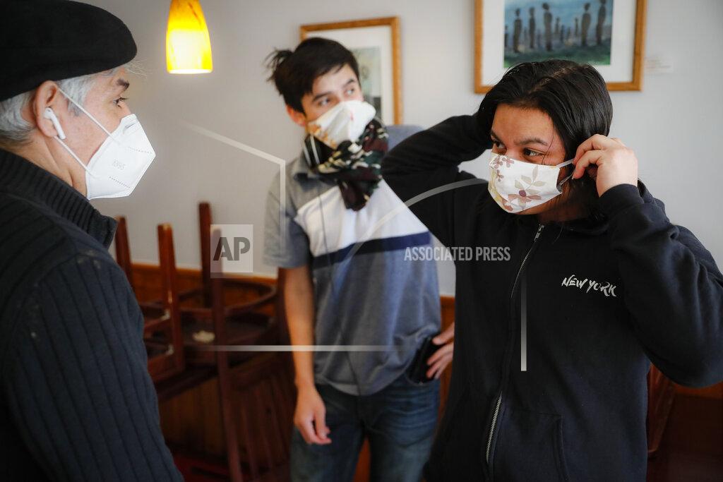 John Minchillo Fabian Arias, a Lutheran pastor with Saint Peter's Church in Manhattan, left, provides protective masks to Jason Mejia, right, and Walter Zaldivar, center, to whom he provides legal guardianship as he buys them dinner, Thursday, May 14, 2020, in West New York, N.J. (AP Photo/John Minchillo)