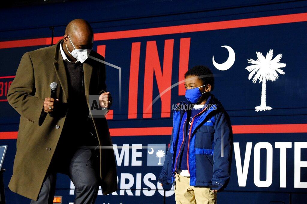 Meg Kinnard Democratic U.S. Senate candidate Jaime Harrison, left, dances onto the stage with his son William, right, at a campaign rally on Monday, Nov. 2, 2020, in Orangeburg, S.C. (AP Photo/Meg Kinnard)