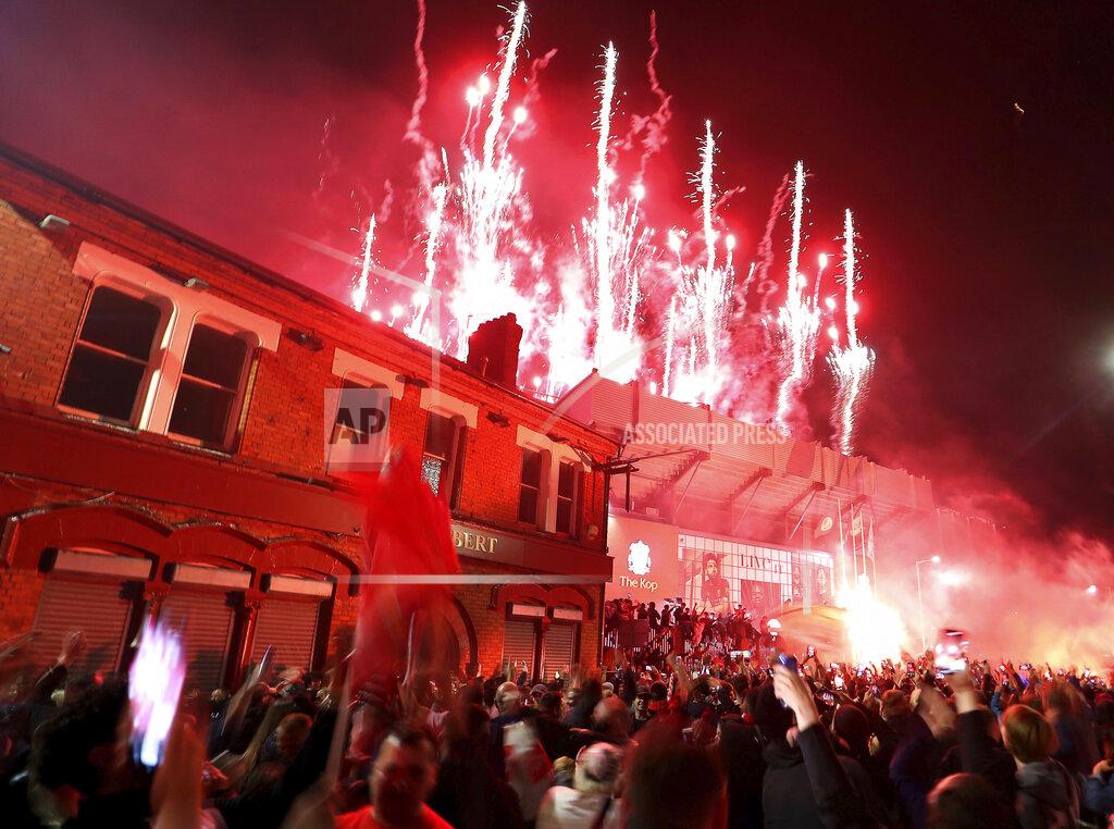 Martin Rickett Liverpool fans celebrate outside Anfield stadium as fireworks are set off as the players receive the Premier League trophy inside the grounds after the English Premier soccer match between Liverpool and Chelsea, Wednesday, July 22, 2020, in Liverpool, England. (Martin Rickett/PA via AP)