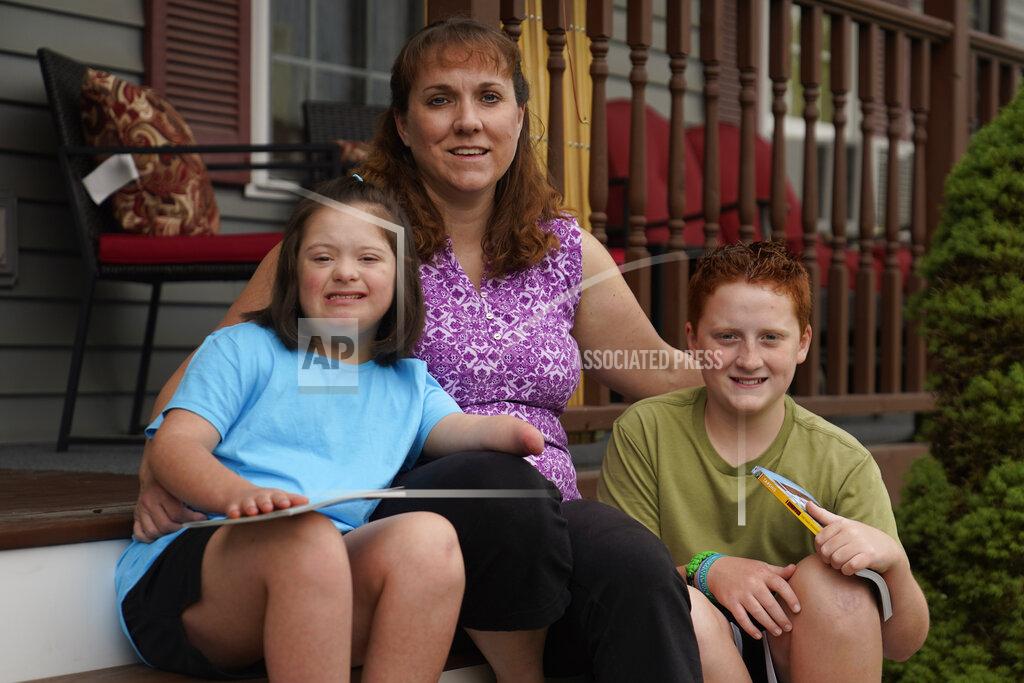 Charles Krupa Jennifer Osgood, center, poses with her children Lily, 7, left, and Noah, 12, right, at their home in Fairfax, Vt., on Tuesday, July 20, 2021. The Osgood children will continued to be homeschool this upcoming school year. As the pandemic took hold across the United States in the spring of 2020, it brought disruption and anxiety to most families. Yet some parents are grateful for one consequence: they are now opting to homeschool their children even as schools plan to resume in-person classes. (AP Photo/Charles Krupa)