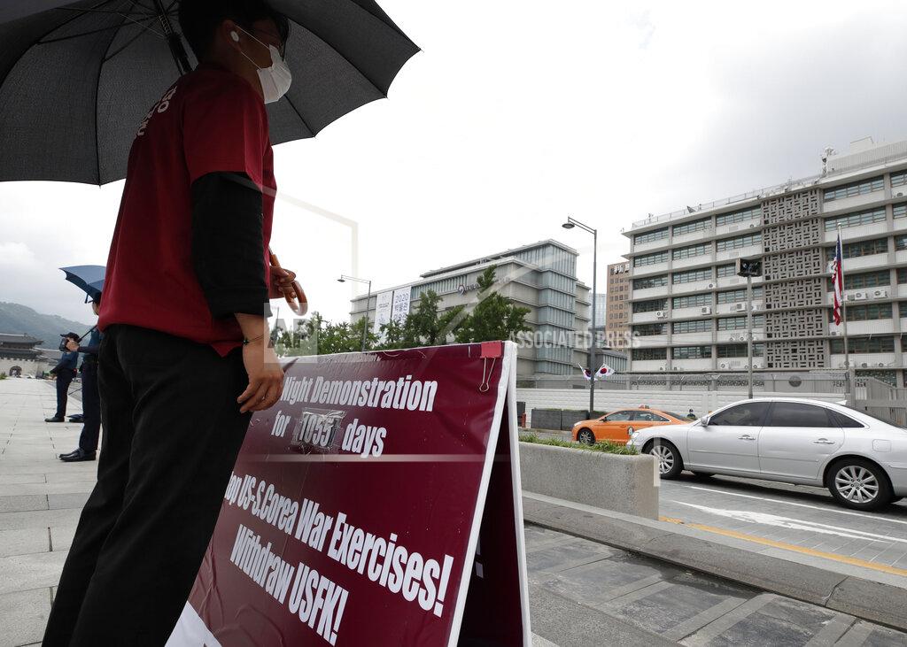 Lee Jin-Man A man stands with a banner to oppose the joint military exercises between South Korea and the United States near the U.S. Embassy in Seoul, South Korea, Sunday, Aug. 16, 2020. The countries will begin their annual joint military exercises this week, Seoul’s Joint Chiefs of Staff said Sunday. But a spreading coronavirus outbreak has apparently forced the allies to scale back an already low-key training program mainly involving computer-simulated war scenarios. (AP Photo/Lee Jin-man)