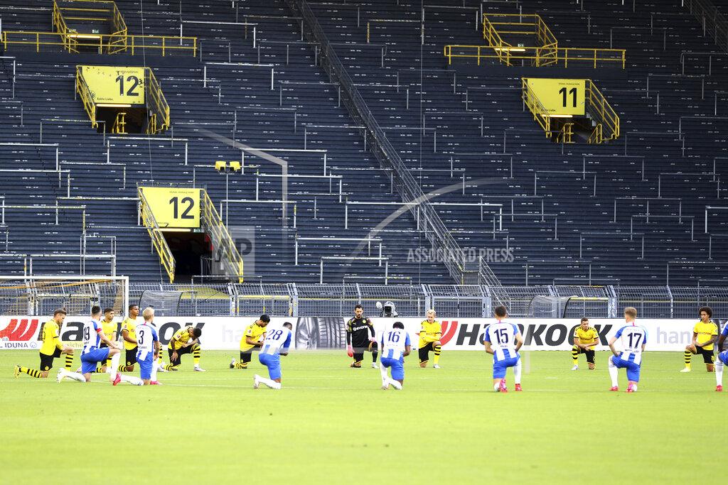 Lars Baron Players of both teams (Dortmund yellow jersey) kneel around the centre circle as a mark of support for the protests after the recent killing of black American George Floyd by police officers in Minneapolis, USA, before the German Bundesliga soccer match between Borussia Dortmund and Hertha BSC Berlin in Dortmund , Germany, Saturday, June 6, 2020. (Lars Baron, Pool via AP)