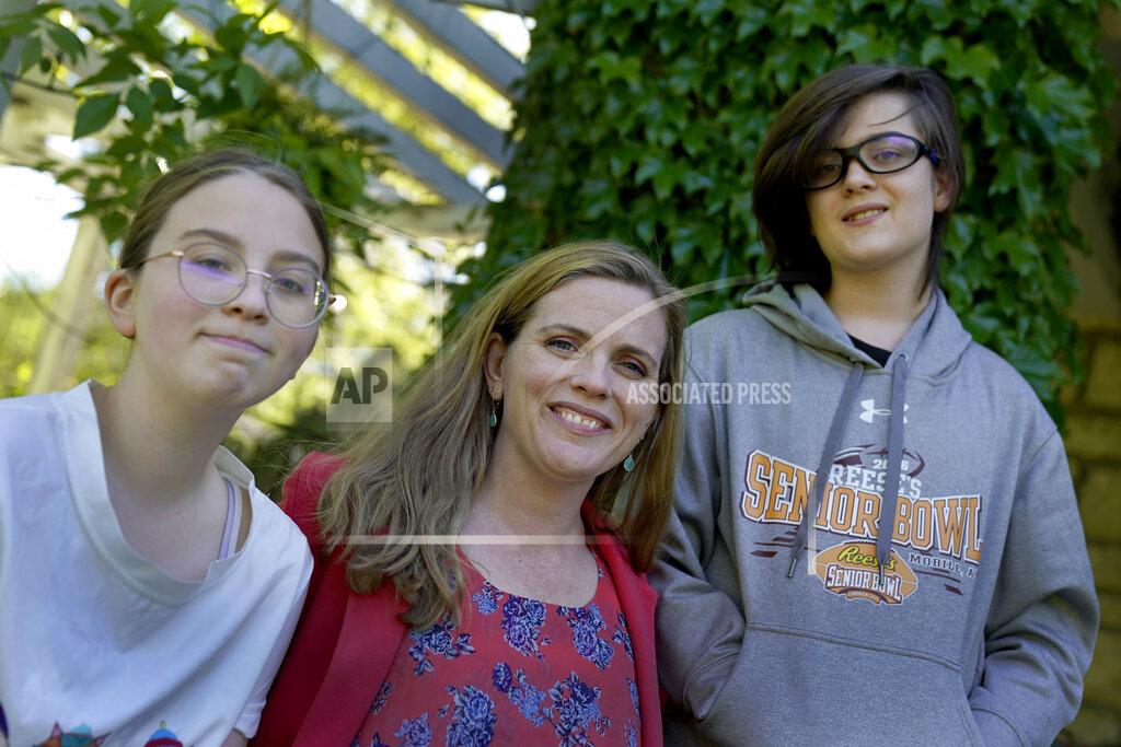 Charlie Riedel Heather Ousley sits with her older children Elliannah, 15, and Samuel, 13, in front of their home in Merriam, Kan, Tuesday, May 4, 2021. Ousley was thrilled when she heard the FDA was expected to authorize Pfizer's COVID-19 vaccine for youngsters ages 12 to 15 and was hoping to get her kids vaccinated as soon as she can. (AP Photo/Charlie Riedel)