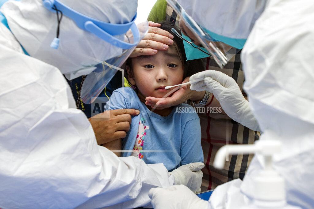 Uncredited A child reacts to a throat swab during mass testing for COVID-19 in Wuhan in central China's Hubei province Tuesday, Aug. 3, 2021. The coronavirus’s delta variant is challenging China’s costly strategy of isolating cities, prompting warnings that Chinese leaders who were confident they could keep the virus out of the country need a less disruptive approach. (Chinatopix via AP)