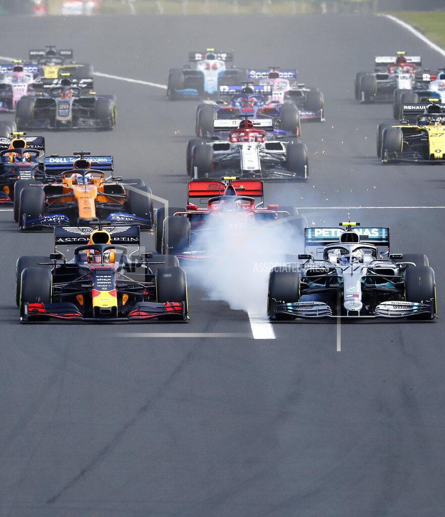 Red Bull driver Max Verstappen, left, of the Netherlands, and Mercedes driver Valtteri Bottas, of Finland, challenge for the first position after starting during the Hungarian Formula One Grand Prix at the Hungaroring racetrack in Mogyorod, northeast of Budapest, Hungary, Sunday, Aug. 4, 2019. (AP Photo/Laszlo Balogh)