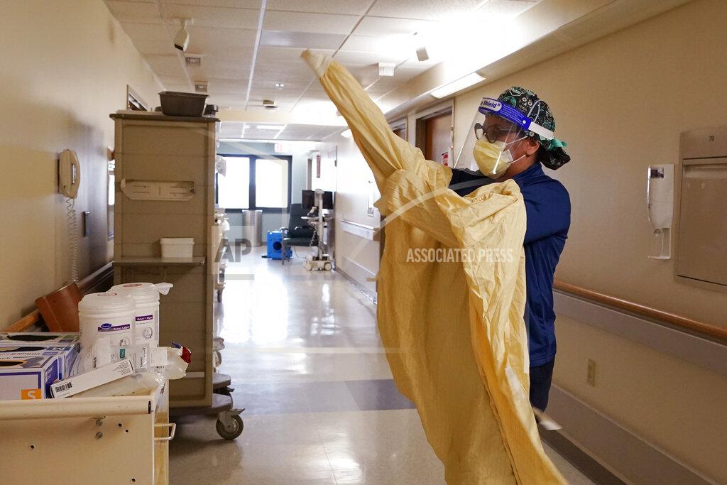 Carlos Osorio FILE - In this April 21, 2021 file photo, a registered dons protective gear before entering a room at a hospital in Royal Oak, Mich. In 2021, U.S. hospitalizations and deaths are nearly all among the unvaccinated, and real-world data from Britain and Israel support that protection against the worst cases remains strong. What scientists call “breakthrough” infections in people who are fully vaccinated make up a small fraction of cases. (AP Photo/Carlos Osorio, File)
