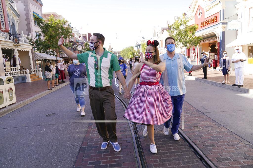 Jae Hong Guests walk down Main Street USA at Disneyland in Anaheim, Calif., Friday, April 30, 2021. The iconic theme park in Southern California that was closed under the state's strict virus rules swung open its gates Friday and some visitors came in cheering and screaming with happiness. (AP Photo/Jae Hong)