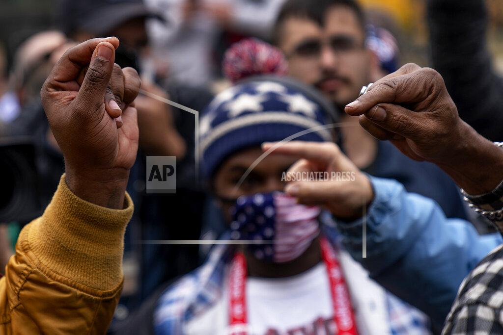 David Goldman The hands of Biden supporter Angelo Austin, and Trump supporter C.L. Bryant, right, gesture as they argue while Trump supporters demonstrate against the election results outside the central counting board at the TCF Center in Detroit, Mich., Thursday, Nov. 5, 2020. (AP Photo/David Goldman)