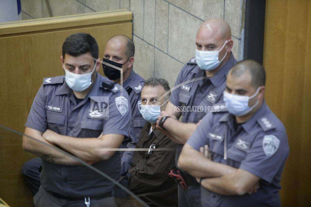 Sebastian Scheiner Yakub Kadari is surrounded by guards in a courtroom in Nazareth, Israel, after he and three other Palestinian fugitives were captured on Saturday, Sept. 11, 2021. Israeli police on Saturday said they have arrested four of the six Palestinians who broke out of a maximum-security prison this week — including a famed militant leader whose exploits over the years have made him a well-known figure in Israel. (AP Photo/Sebastian Scheiner)