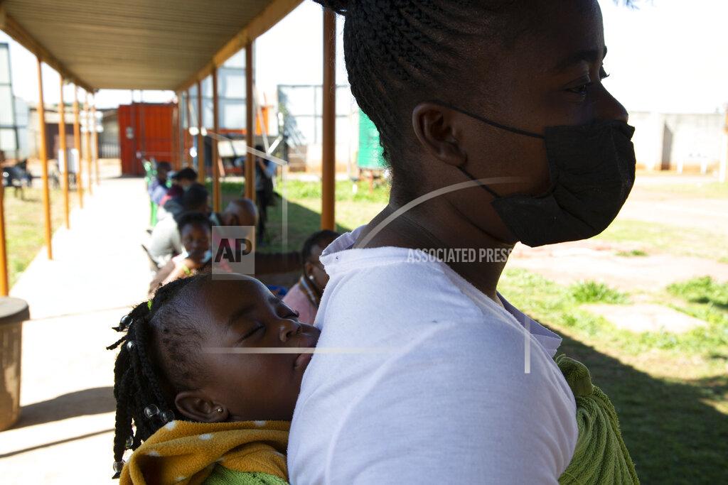 Denis Farrell A woman with a child on her back waits in a queue to be screened for COVID-19 at a testing centre in Soweto, South Africa, Wednesday, May 11, 2022. Health experts in South Africa say the country is experiencing a surge of new COVID-19 cases driven by two omicron sub-variants. Professor Marta Nunes, a researcher at Vaccine and Infectious Diseases Analytics at Chris Hani Baragwanath Hospital in Soweto said that for about three weeks the country has seen increasing numbers of new cases and somewhat higher hospitalizations, but not increases in severe cases and deaths. (AP Photo/Denis Farrell)