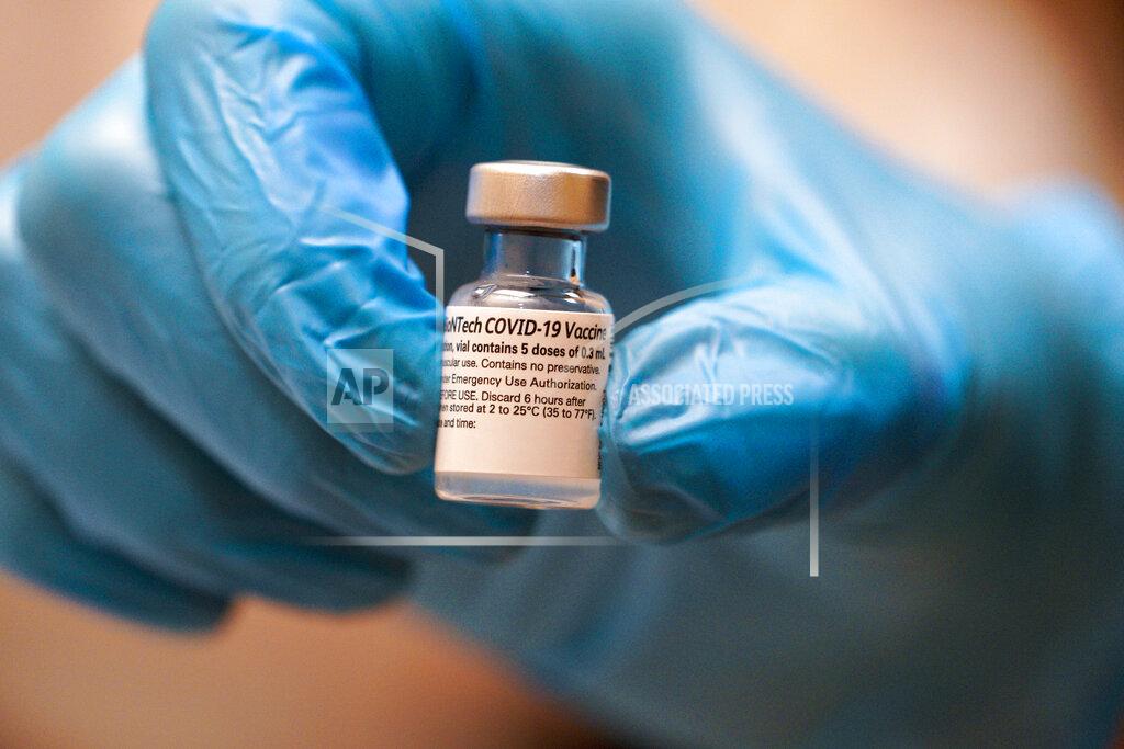 Nelvin C. Cepeda A Scripps health official holds a COVID-19 vaccination prior to administering it at their new drive-thru vaccination site at the Del Mar Fairgrounds on Friday, Feb. 12, 2021, in Del Mar, Calif. (Nelvin C. Cepeda/The San Diego Union-Tribune via AP, Pool)