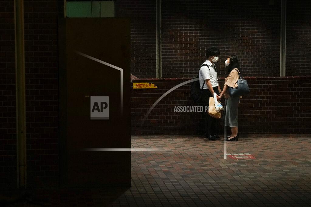 Jae C. Hong A couple hold hands at a subway station ahead of the 2020 Summer Olympics on Wednesday, July 14, 2021, in Tokyo. (AP Photo/Jae C. Hong)