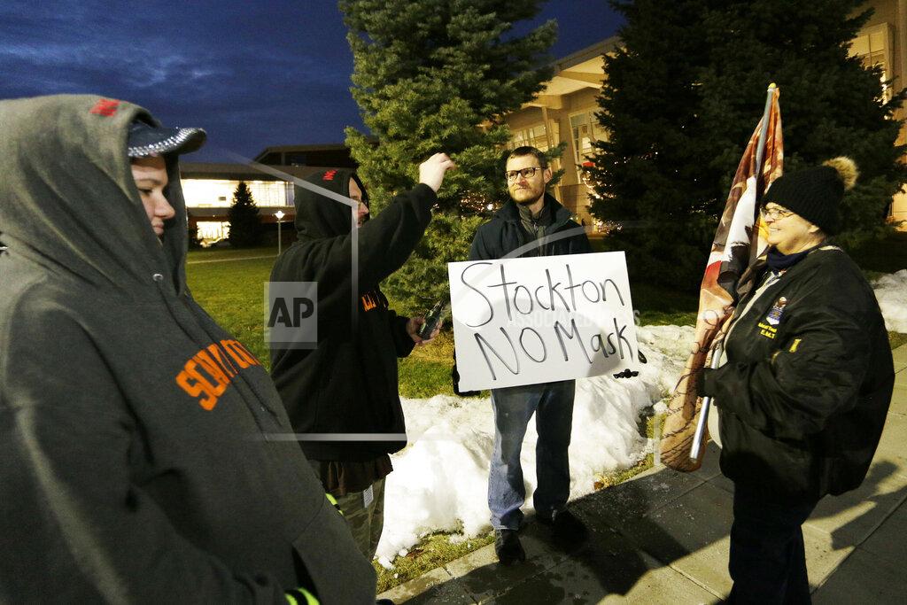 Young Kwak Rebecca Ducharme, left to right, Trevor Ducharme, an unidentified person and Charlie Giglio protest the revocation of former Gonzaga player John Stockton's season tickets due to his refusal to follow the mask mandate, outside the McCarthey Athletic Center before an NCAA college basketball game between Gonzaga and Portland, Jan. 29, 2022, in Spokane, Wash. (AP Photo/Young Kwak)