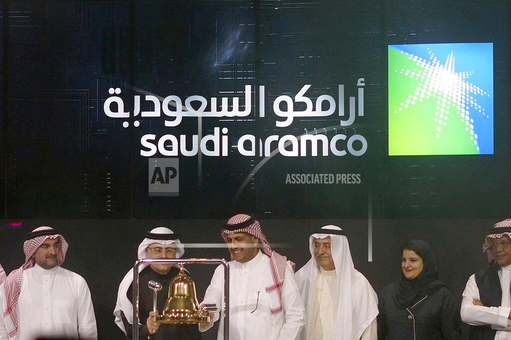 FILE - In this Dec. 11, 2019, file photo, Saudi Arabia's state-owned oil company Armco and stock market officials celebrate during the official ceremony marking the debut of Aramco's initial public offering (IPO) on the Riyadh's stock market, in Riyadh, Saudi Arabia. Saudi Arabia's oil giant Aramco announced Monday, Nov. 16, 2020, it will issue international bonds as it seeks a cash infusion to help pay for billions of dollars in dividends the company promised shareholders before the global coronavirus pandemic sent oil prices plummeting. (AP Photo/Amr Nabil, File)