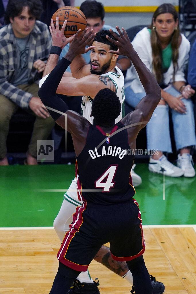 Charles Krupa Boston Celtics forward Jayson Tatum, top, looks to pass while pressured by Miami Heat guard Victor Oladipo (4) during the second half of Game 4 of the NBA basketball playoffs Eastern Conference finals, Monday, May 23, 2022, in Boston. (AP Photo/Charles Krupa)