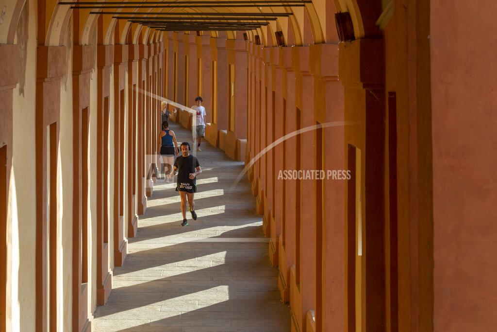 Guido Calamosca People walk along the porticoes in Bologna, Italy, Wednesday, July 28, 2021. Bologna's 12th-century porticoes, still part of the city's everyday life, have been added to the World Heritage List. At a meeting in China on Wednesday, the World Heritage Committee of UNESCO, the U.N. culture agency, inscribed the porticoes on the prestigious list. The addition raises to 58 the number of Italian sites on the list. (Guido Calamosca/LaPresse via AP)