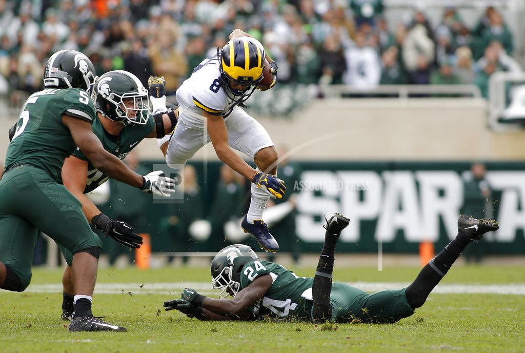 Al Goldis Michigan receiver Ronnie Bell (8) leaps over Michigan State's Tre Person (24) as Michigan State's Andrew Dowell (5) and Kenny Willekes pursue during the second quarter of an NCAA college football game, Saturday, Oct. 20, 2018, in East Lansing, Mich. (AP Photo/Al Goldis)