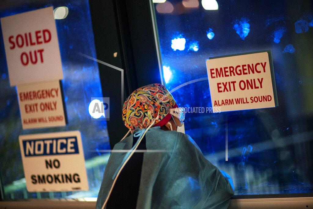 David Goldman Registered traveling nurse Patricia Carrete, of El Paso, Texas, takes a rest to look out a door during a night shift at a field hospital set up to handle a surge of COVID-19 patients, Wednesday, Feb. 10, 2021, in Cranston, R.I. In a two-story office building on a busy commercial street, medical workers opened a COVID-19 field hospital late last November, just before Rhode Island's infection rate became the world's highest. While the state's infection rates have dropped, doctors are glad the field hospital is there to relieve pressure on their staffs. (AP Photo/David Goldman)