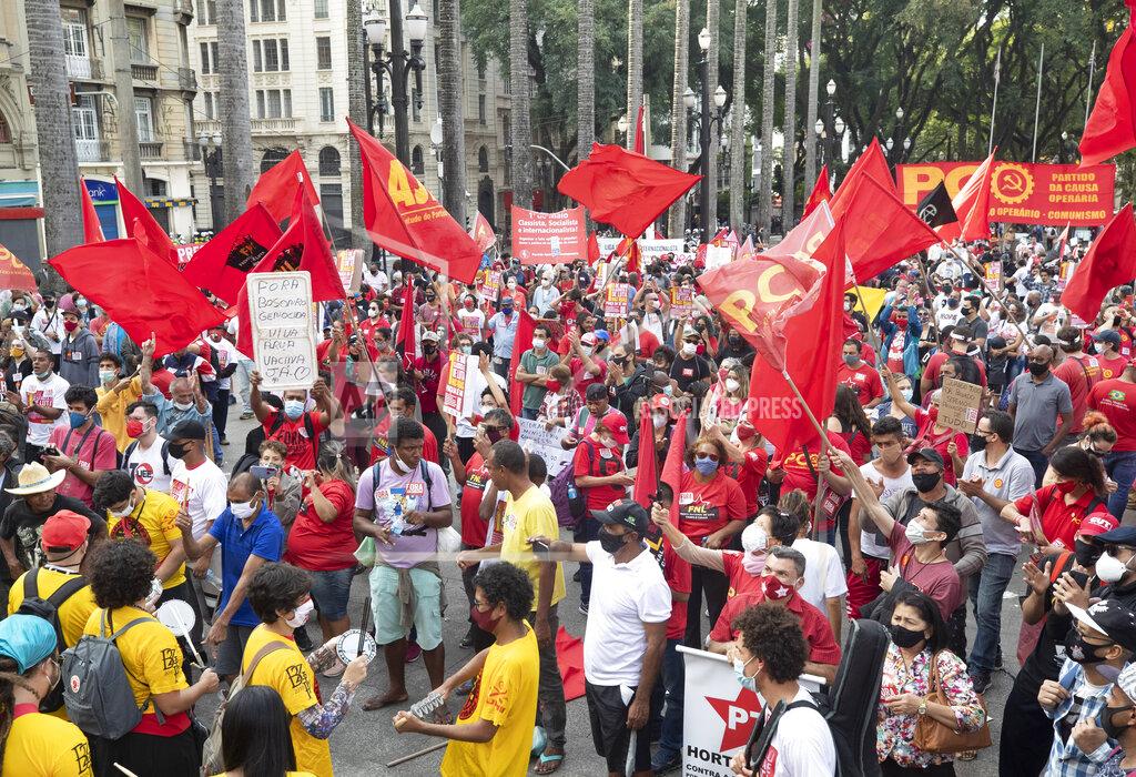 Andre Penner Demonstrators take part in a protest against Brazil's President Jair Bolsonaro and his handling of the new coronavirus pandemic, marking May Day, or International Workers' Day, outside the Cathedral in Sao Paulo, Brazil, Saturday, May 1, 2021. (AP Photo/Andre Penner)