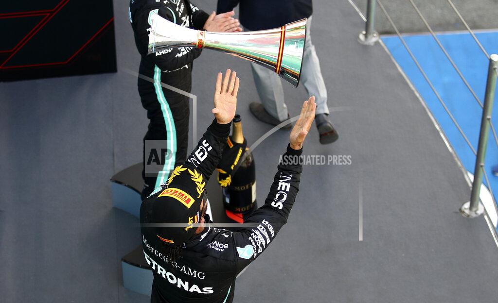 Bryn Lennon Mercedes driver Lewis Hamilton of Britain celebrates on the podium after winning the Formula One Grand Prix at the Barcelona Catalunya racetrack in Montmelo, Spain, Sunday, Aug. 16, 2020. (Bryn Lennon, Pool via AP)