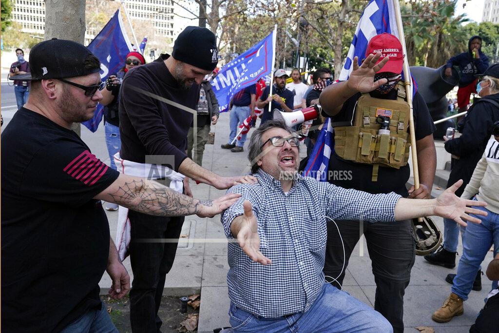 Demonstrators pray during a pro-Trump rally outside of City Hall Wednesday, Jan. 6, 2021, in Los Angeles. Demonstrators, supporting President Donald Trump, are gathering in various parts of Southern California as Congress debates to affirm President-elect Joe Biden's electoral victory. (AP Photo/Marcio Jose Sanchez)