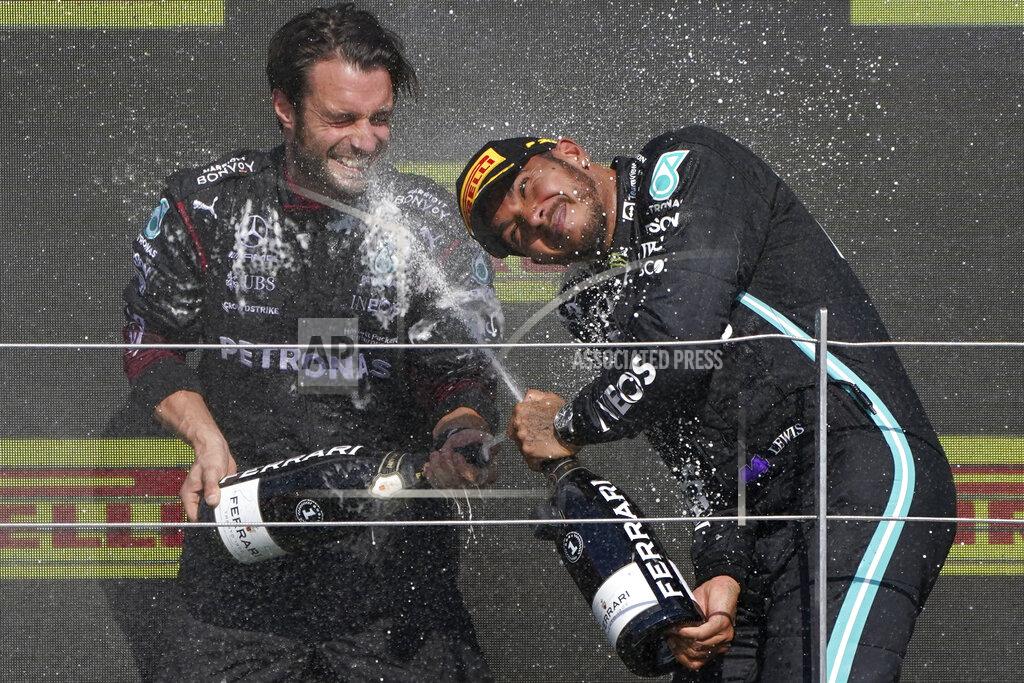 Jon Super Mercedes driver Lewis Hamilton of Britain, right, celebrates on the podium after winning the British Formula One Grand Prix, at the Silverstone circuit, in Silverstone, England, Sunday, July 18, 2021. (AP Photo/Jon Super)