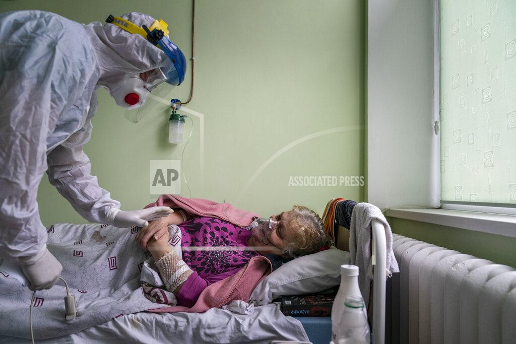 Evgeniy Maloletka Dr. Oleh Hornostayev speaks to a coronavirus patient at the hospital in Stryi, Ukraine, on Tuesday, Sept. 29, 2020. Coronavirus infections in Ukraine began surging in late summer, and the ripples are hitting towns in the western part of the country. The government wants to avoid imposing a new lockdown, but officials acknowledge that the rising infections could make it necessary. (AP Photo/Evgeniy Maloletka)