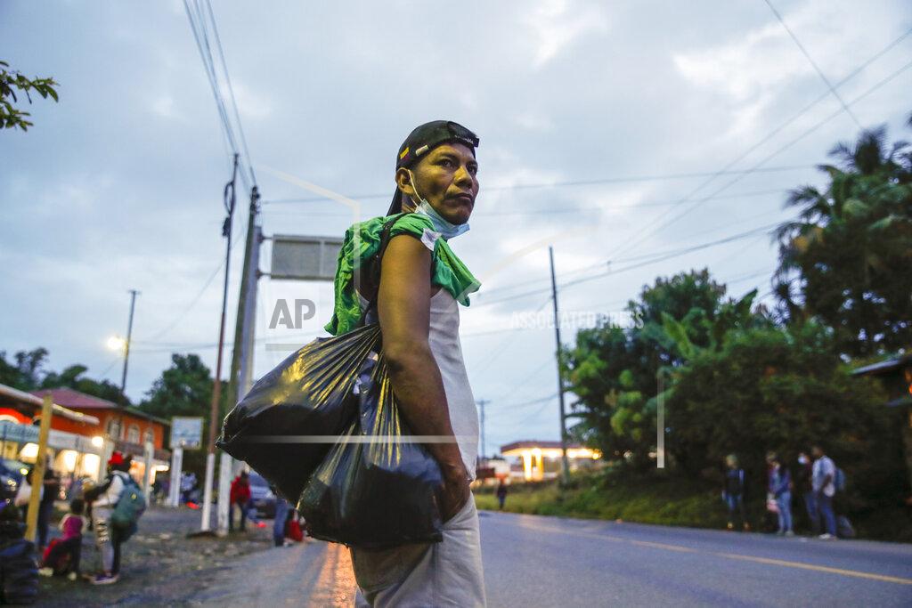 Moises Castillo An Honduran migrant stands on the side of a highway in Puerto Barrios, Guatemala, Friday, Oct. 2, 2020. About 2,000 Honduran migrants hoping to reach the United States entered Guatemala on foot Thursday, but President Guatemalan President Alejandro Giammattei vowed to detain them and return them to their home country saying they represented a health threat amid efforts to contain the coronavirus pandemic. (AP Photo/Moises Castillo)