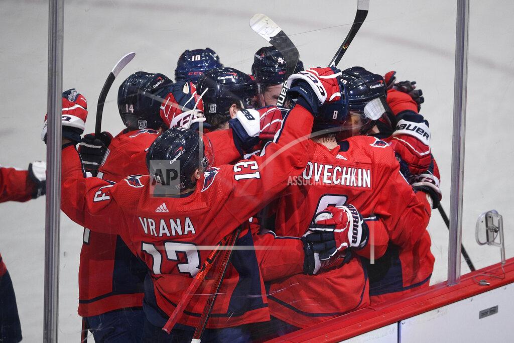 Nick Wass Washington Capitals left wing Alex Ovechkin (8) is mobbed by his teammates after he scored the winning goal in overtime of an NHL hockey game against the Boston Bruins, Saturday, Jan. 30, 2021, in Washington. (AP Photo/Nick Wass)