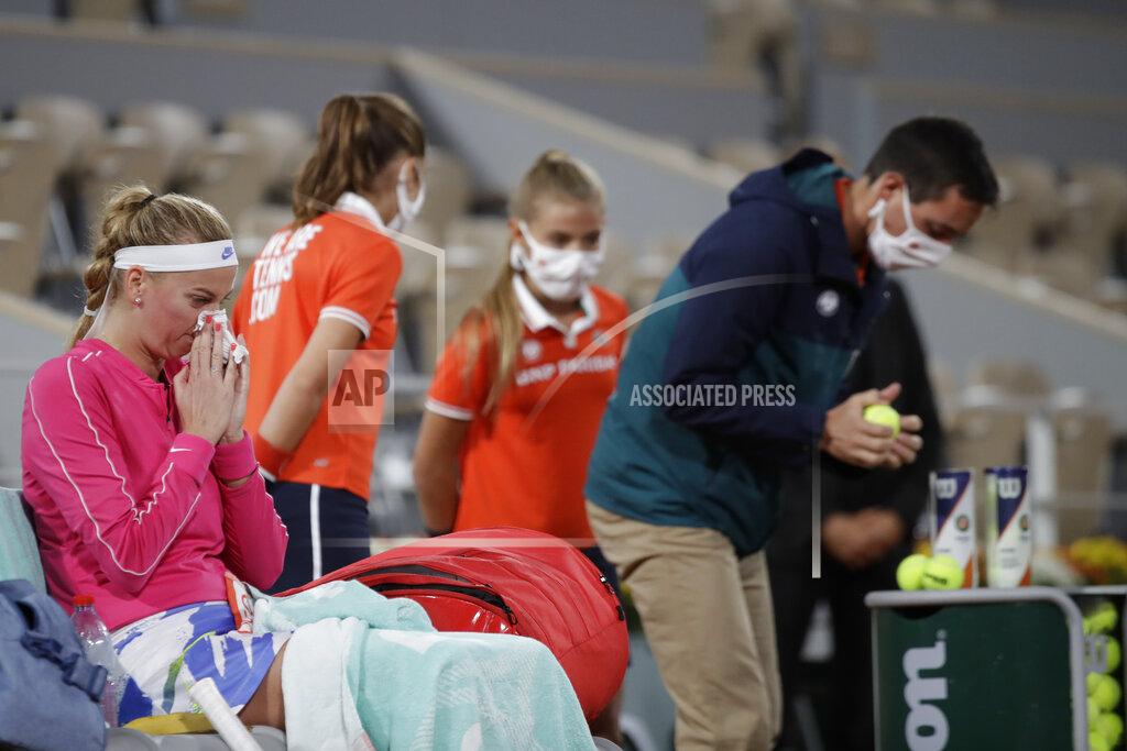Alessandra Tarantino Petra Kvitova of the Czech Republic wipes her nose as an official, right, tests the balls in the first round match of the French Open tennis tournament against France's Oceane Dodin at the Roland Garros stadium in Paris, France, Monday, Sept. 28, 2020. (AP Photo/Alessandra Tarantino)