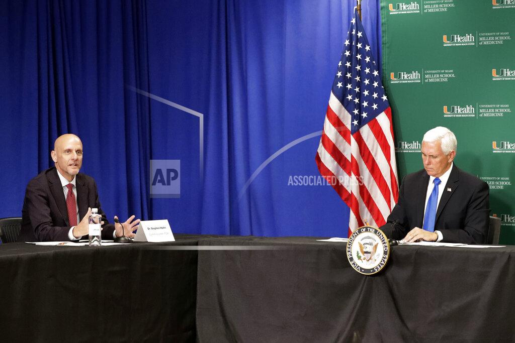 Vice President Mike Pence, right, listens as Food and Drug Administration Commissioner Dr. Stephen Hahn, left, speaks during a roundtable discussion at the University of Miami Miller School of Medicine
Don Soffer Clinical Research Center, Monday, July 27, 2020, in Miami. Pence was in Florida to mark the beginning of Phase III trials for a Coronavirus vaccine. (AP Photo/Wilfredo Lee)