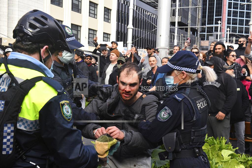 Mick Tsikas A protester, center, is arrested by police at a demonstration at Sydney Town Hall during a 'World Wide Rally For Freedom' anti-lockdown rally in Sydney, Saturday, July 24, 2021. (Mick Tsikas/AAP Image via AP)