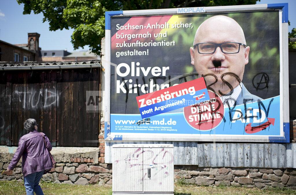 A vandalized election campaign poster for the far-right Alternative for Germany party showing the party's top candidate, Oliver Kirchner, stands on a road in Saxony-Anhalt's state capital of Magdeburg, Germany, Wednesday, June 2, 2021. The state vote on Sunday, June 6, 2021 is German politicians' last major test at the ballot box before the national election in September that will determine who succeeds Chancellor Angela Merkel. After a mustache and the words "Hitler's heirs" were sprayed on the poster, the party added a sticker reading: 'Destruction instead of arguments?' The AFD election campaign slogan reads: ' Make Saxony-Anhalt safe, close to the citizen and future-oriented'. (AP Photo/Markus Schreiber)