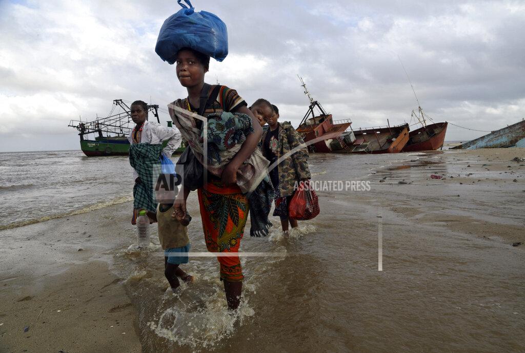 Tsvangirayi Mukwazhi FILE — In this Saturday, March 23, 2019 file photo, displaced families arrive after being rescued by boat from a flooded area of Buzi district, 200 kilometers (120 miles) outside Beira, Mozambique. The U.N. high commissioner for refugees, Filippo Grandi said Friday June 17, 2021, that conflicts and the impact of climate change in places like Mozambique were among the leading sources of new flows of refugees and internally displaced people in 2020. (AP Photo/Tsvangirayi Mukwazhi, File)