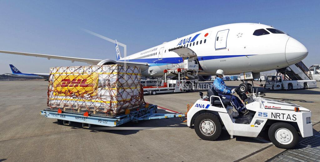 Kenzaburo Fukuhara A man moves containers of coronavirus vaccine imported by an All Nippon Airways airplane after it arrived at Narita International Airport in Narita, east of Tokyo on Sunday, Feb. 21, 2021. (Kenzaburo Fukuhara/Kyodo News via AP)