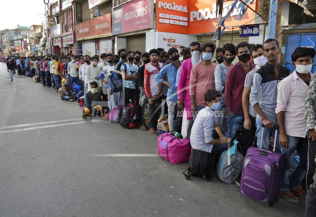 Ajit Solanki Migrant workers from other states trying to return to their homes stand in queue as they wait for transportation to a train station in Ahmedabad, India, Sunday, May 17, 2020. Tens of thousands of migrant laborers have been returning from big cities to their villages after losing jobs because of a countrywide lockdown imposed in late March to contain the spread of the coronavirus. (AP Photo/Ajit Solanki)