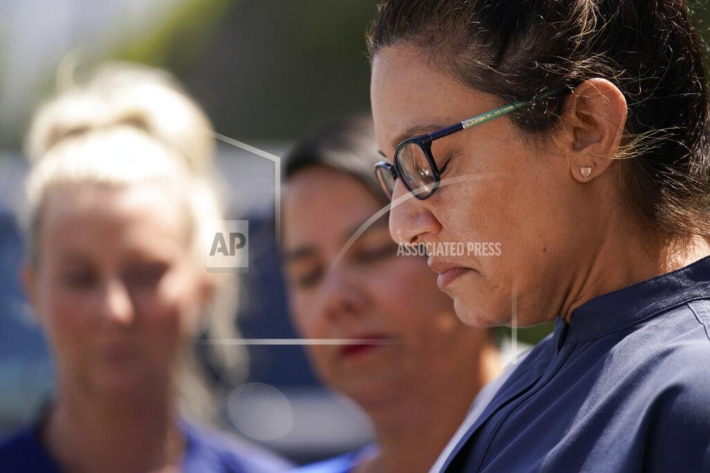 Ashley Landis Erica Triplett, right, an office manager for Dr. John Cheng, is emotional as she reads a statement outside their office building on Tuesday, May 17, 2022, in Aliso Viejo, Calif. Cheng, 52, was killed in Sunday's shooting at Geneva Presbyterian Church. At left is Crystal Cole, an executive assistant who worked with Cheng, and Johnna Gherardini, executive director of South Coast Medical Group, where Cheng worked. (AP Photo/Ashley Landis)