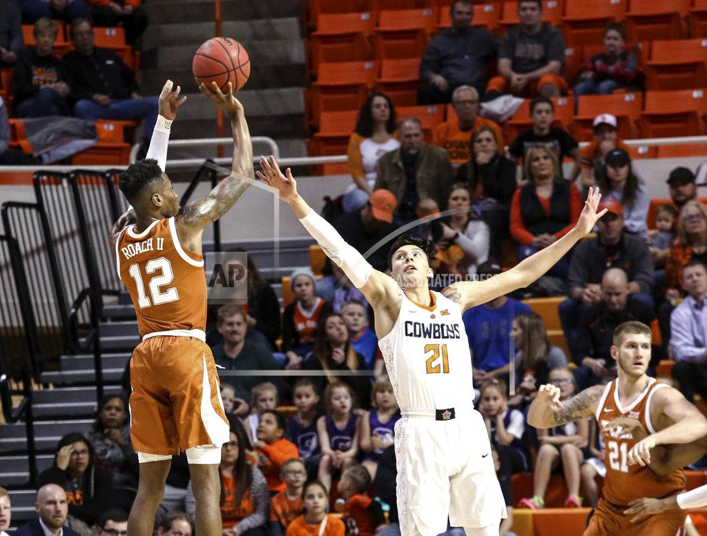 Evan Brown Texas' Kerwin Roach II attempts a 3-point shot over Oklahoma State's Lindy Waters during the first half of an NCAA college basketball game Tuesday, Jan. 8, 2019, in Stillwater, Okla. (Evan Brown/Tulsa World via AP)