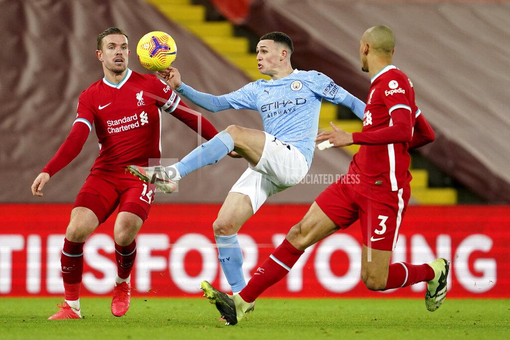 Jon Super Manchester City's Phil Foden controls the ball between Liverpool's Jordan Henderson, left, and Liverpool's Fabinho during the English Premier League soccer match between Liverpool and Manchester City at Anfield Stadium, Liverpool, England, Sunday, Feb. 7, 2021. (AP photo/Jon Super, Pool)